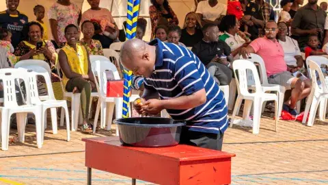 Parents vs teachers game - cup lifting with a balloon