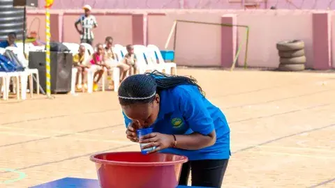 Parents vs teachers game - cup lifting with a balloon
