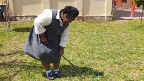 Prenisha, used a rake to gather leaves and other loose materials on the ground.